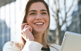A smiling woman looking down at her iPad