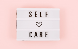 A sign with a heart and the words self care