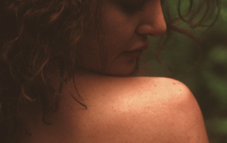 A woman looking over her bare shoulder